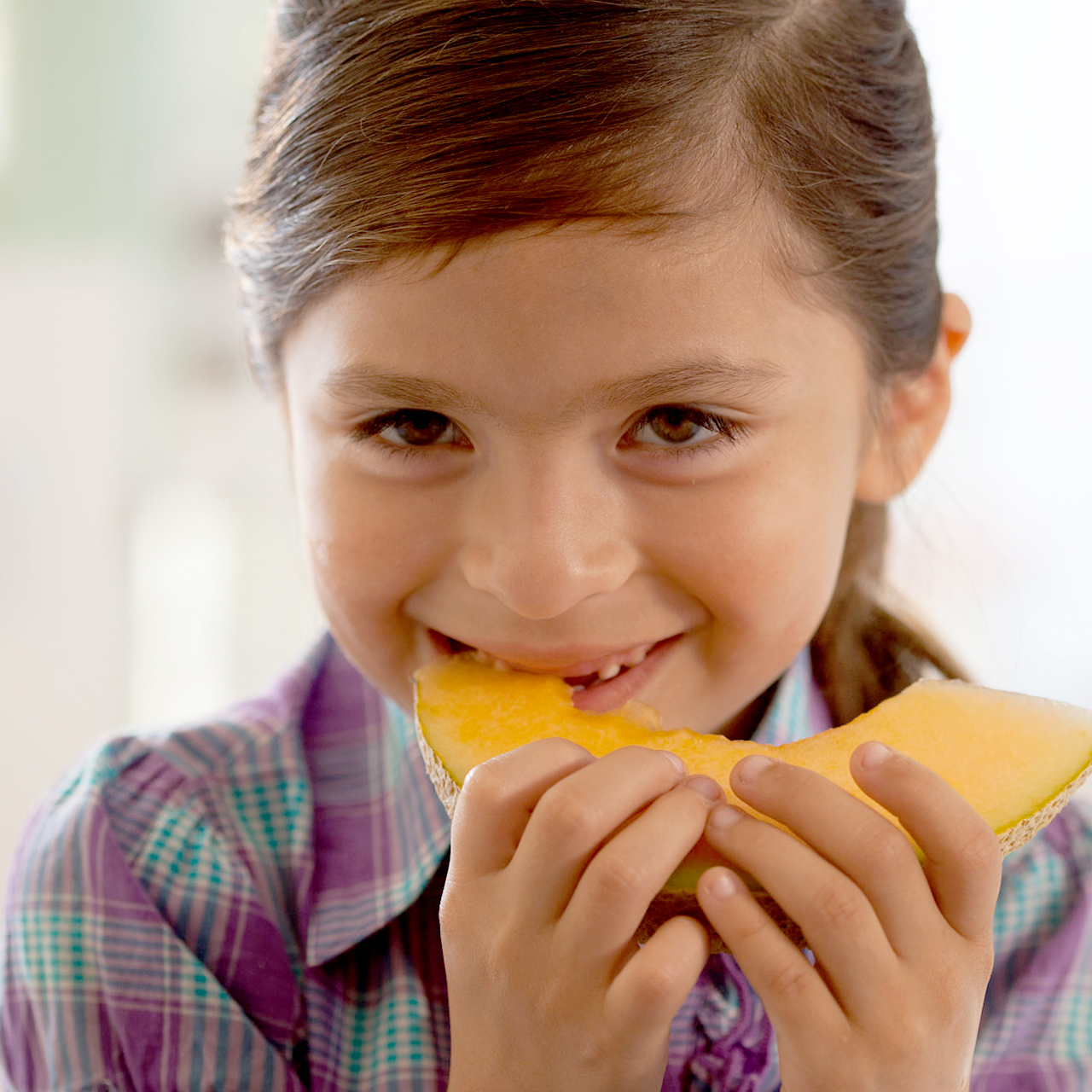 Una niña comiendo melón