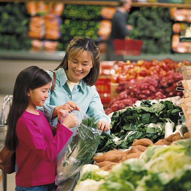 Photo of mother and daughter purchasing fresh vegetables.