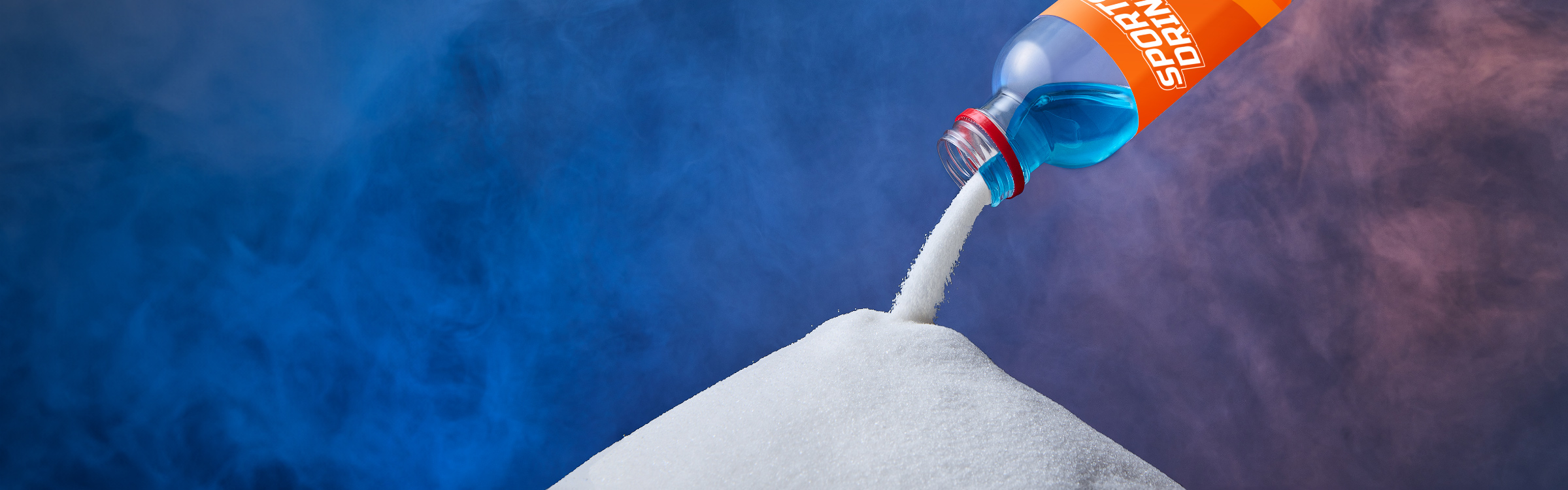 A stream of sugar is being poured onto a pile of sugar.