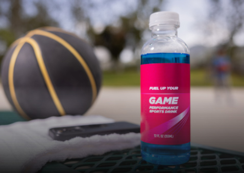 A bottle of a sugary sports drink next to a basketball.