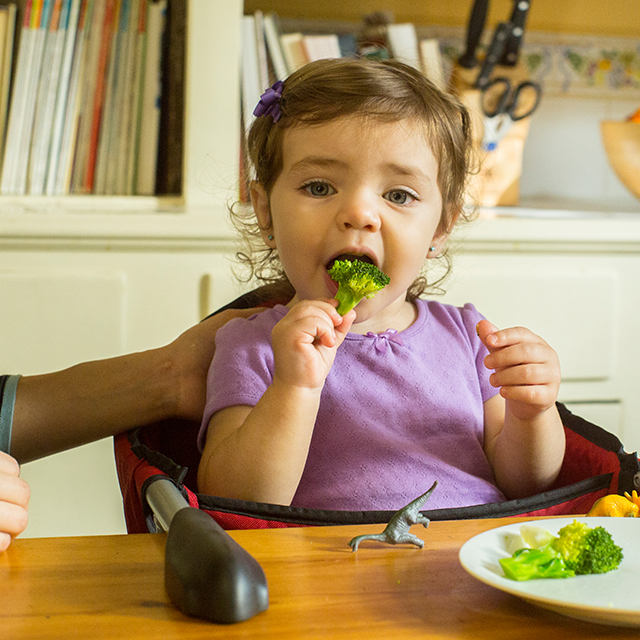 Una bebe comiendo brócoli