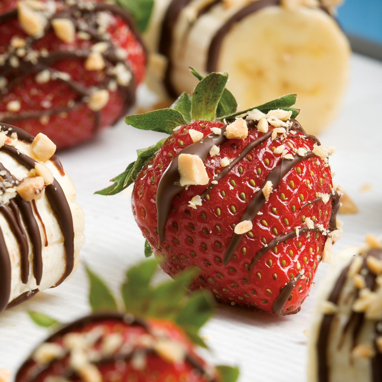 A picture of chocolate covered strawberries with crushed nuts on top.