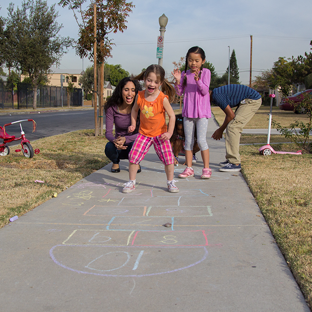 Photo of family playing hopscotch.