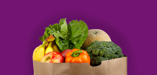 A paper bag filled with a variety of fresh fruits and vegetables.