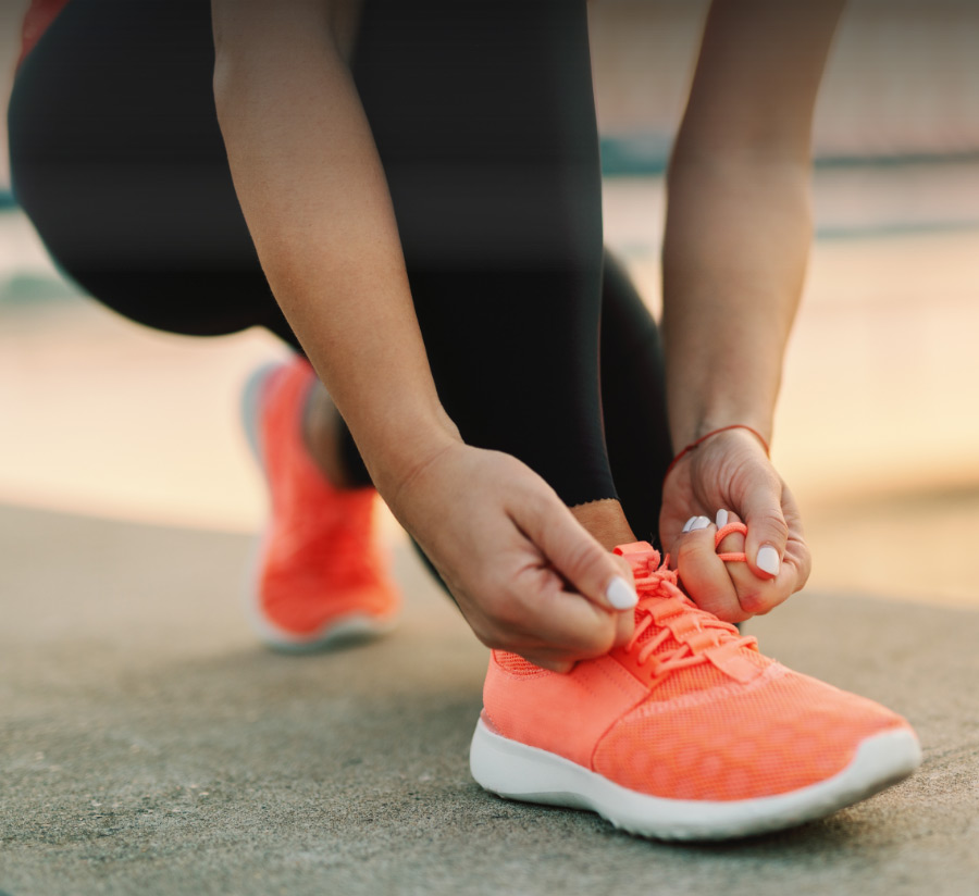 Mujer atándose los tenis para correr.