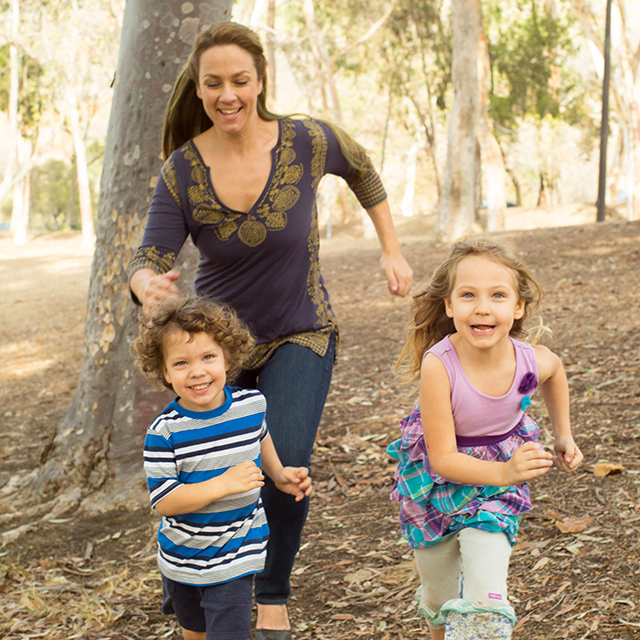 Mamá y niños corriendo en los árboles